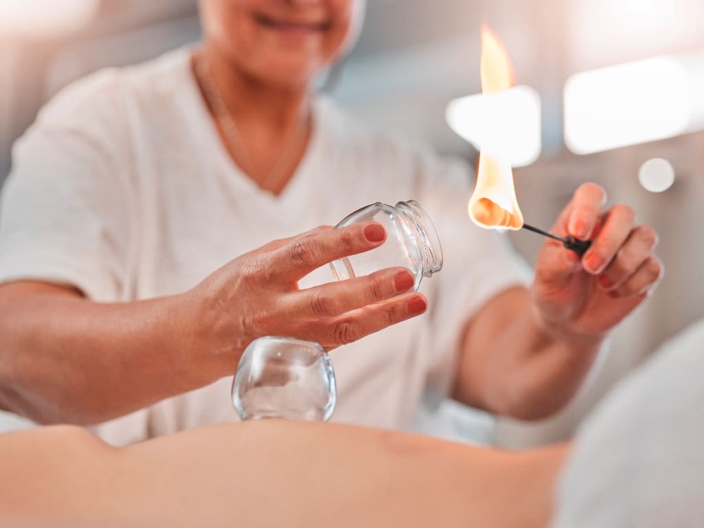 Mujer, manos o llamas para terapia de ventosas en spa, salón de hotel o tratamiento chino holístico para aliviar el dolor, estrés muscular o lesiones. zoom, masajista o fuego en vaso de vidrio para la curación del bienestar